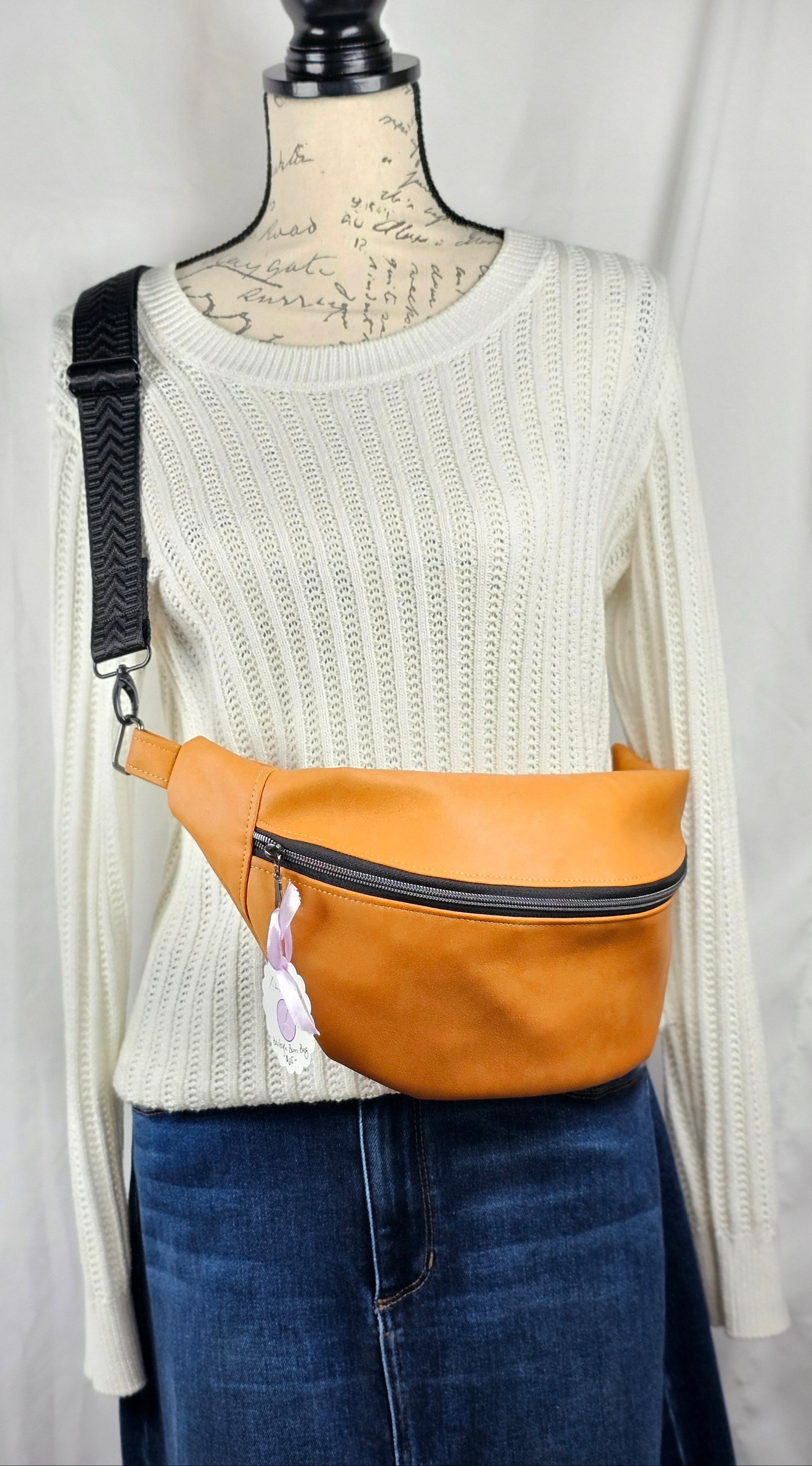 Tan faux leather bum bag, sling bag with fun cat ug cotton lining, black textured strap, with interior zippered and slip pockets.