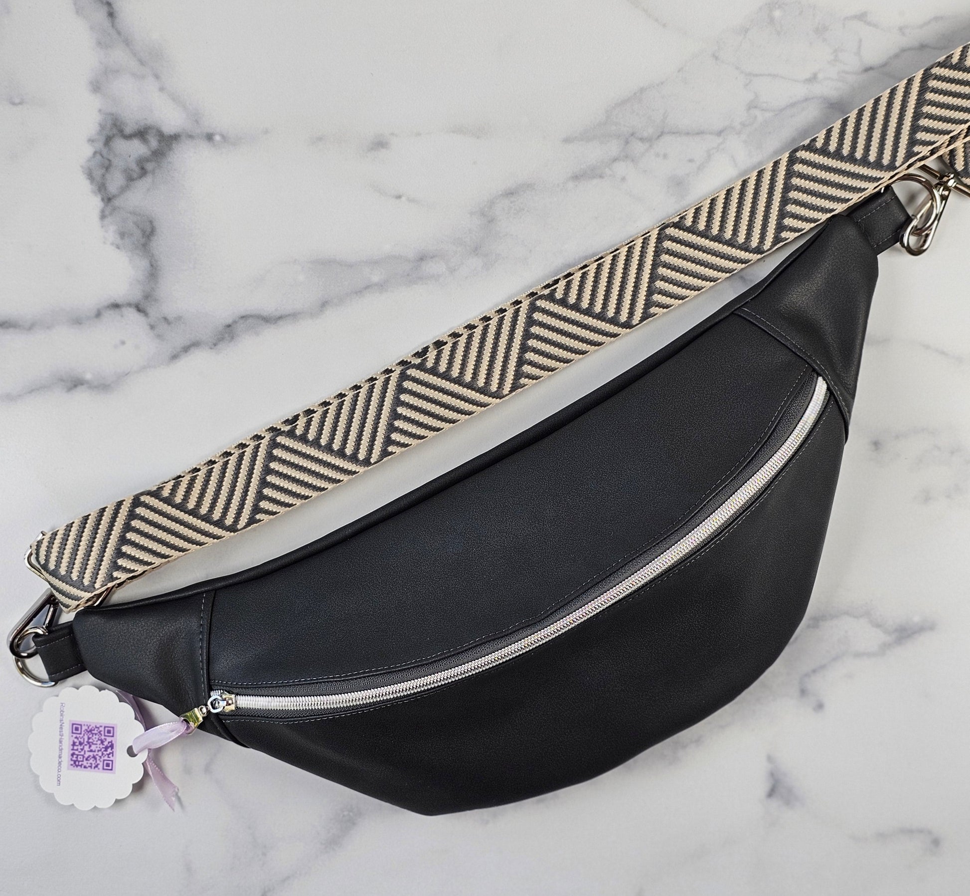 Dark gray sling bag with a striped strap and a gray mushroom cotton canvas interior fabric.