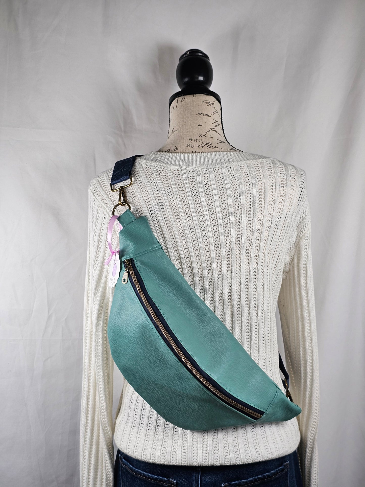 Light blue fanny pack on a white surface with a neutral background