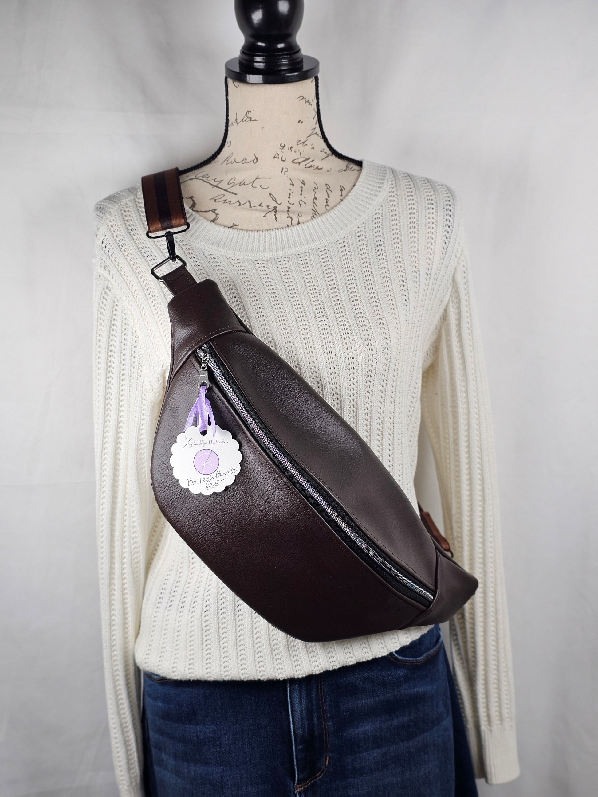 Brown faux leather belt bag with interior dot cotton fabric design on a white sweater and gray background