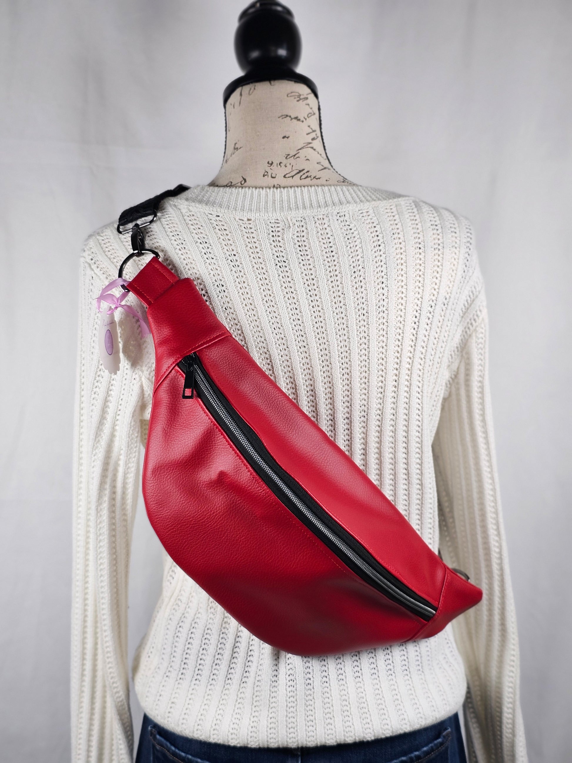 Red faux leather sling fanny pack with mushroom cotton lining and one slip pocket