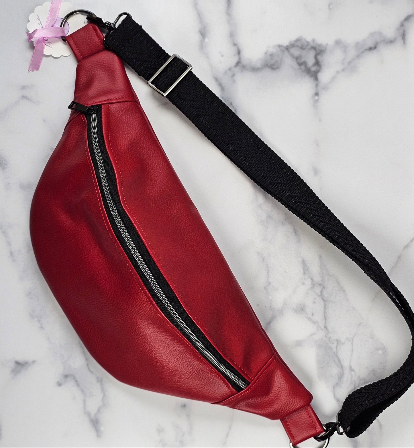 Red faux leather sling fanny pack with mushroom cotton lining and one slip pocket