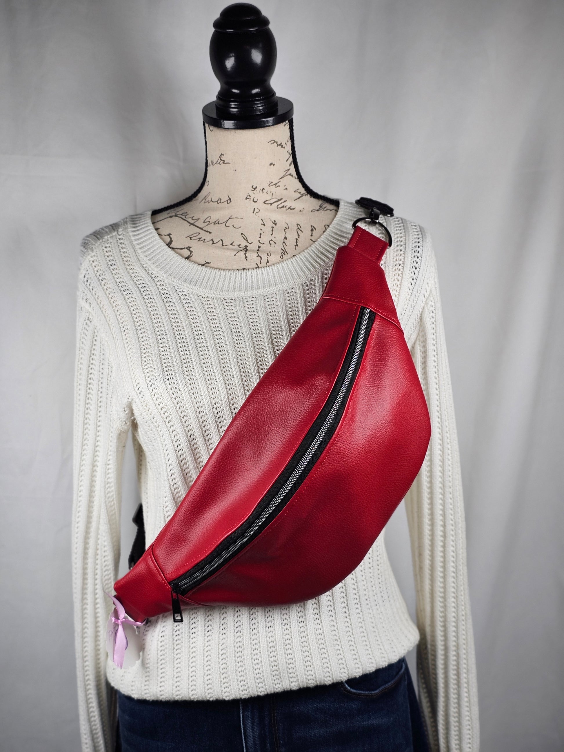 Red faux leather sling fanny pack with mushroom cotton lining and one slip pocket