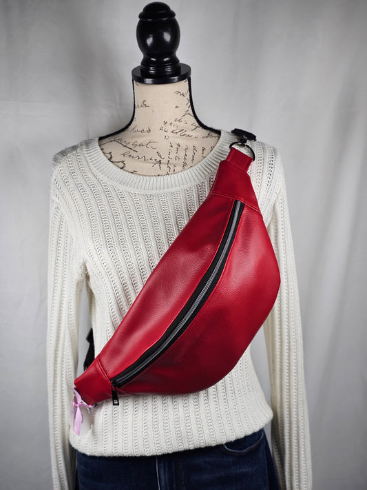 Red faux leather sling fanny pack with mushroom cotton lining and one slip pocket