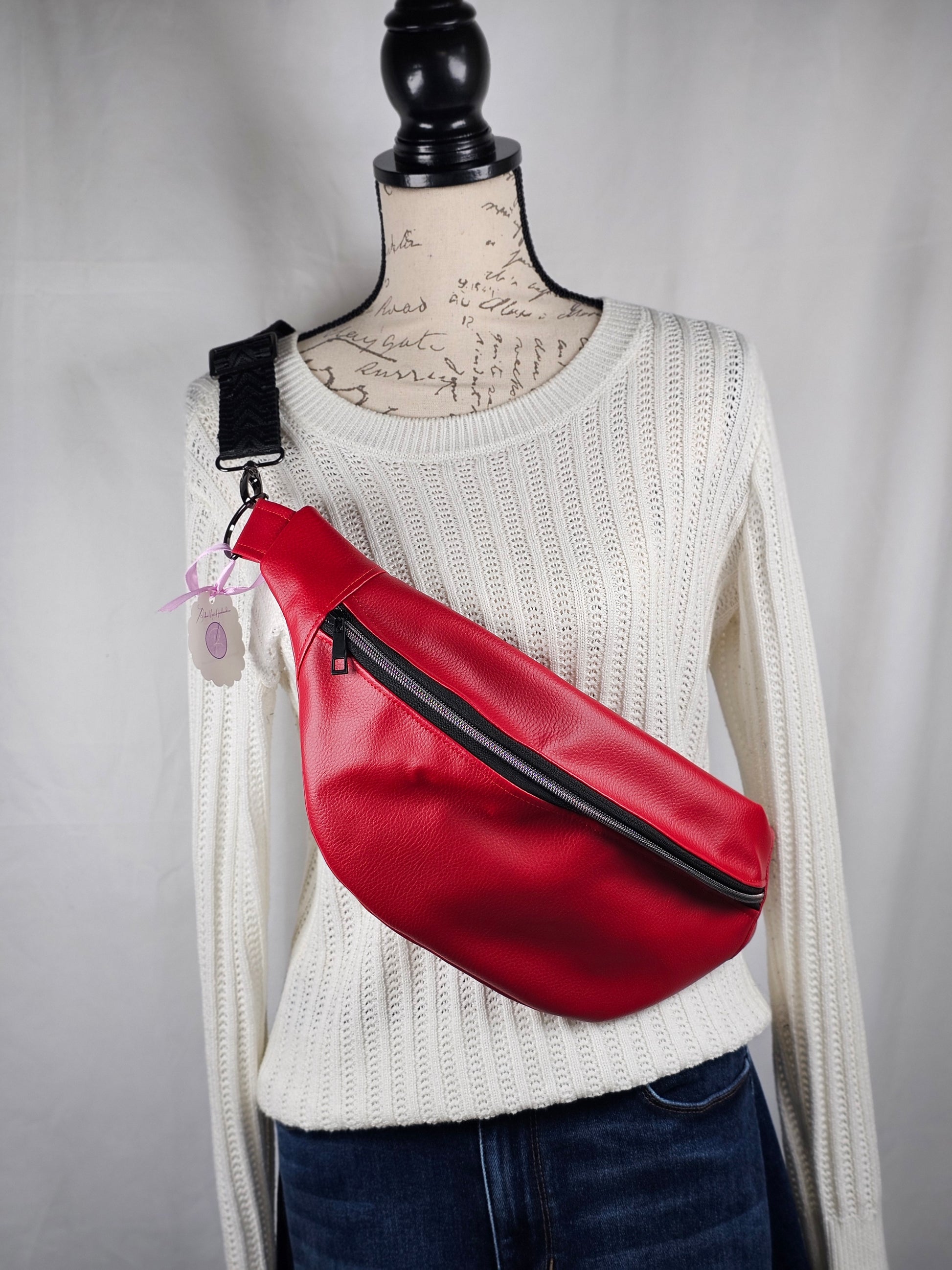 Red faux leather sling fanny pack with mushroom cotton lining and one slip pocket